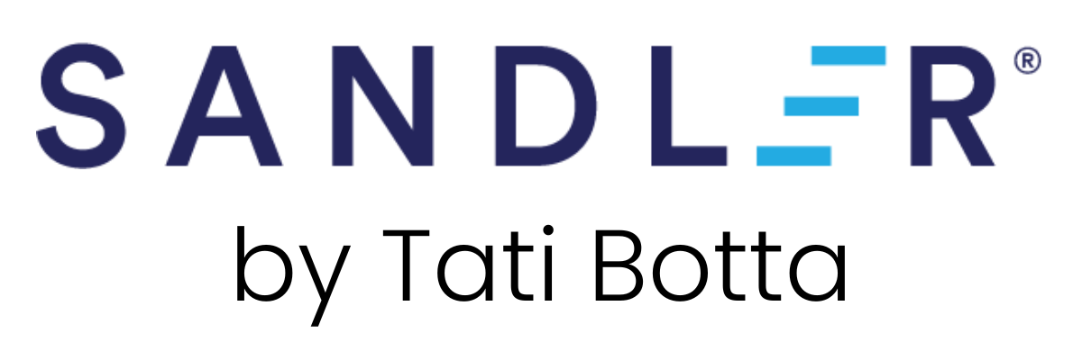 A women smilling and seating in a chair looking direct to the camera.